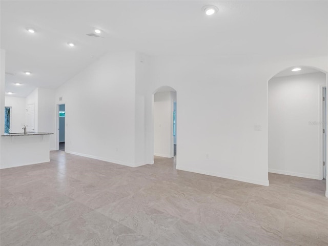 unfurnished living room featuring high vaulted ceiling