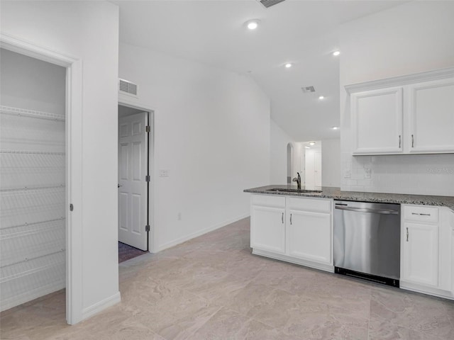 kitchen featuring dishwasher, white cabinets, dark stone counters, and sink