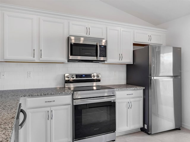 kitchen featuring vaulted ceiling, light stone countertops, stainless steel appliances, and white cabinetry