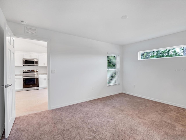 unfurnished room featuring light colored carpet