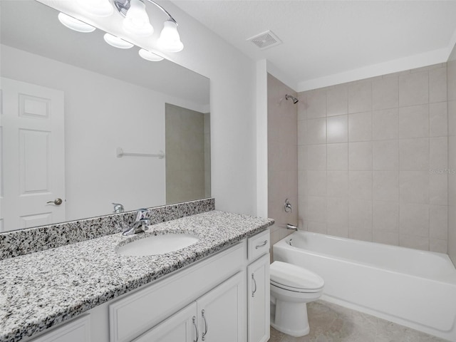 full bathroom with toilet, tile patterned flooring, tiled shower / bath, and vanity