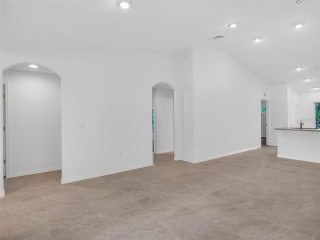 unfurnished living room with sink and lofted ceiling