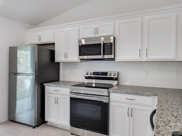 kitchen with vaulted ceiling, stainless steel appliances, and white cabinetry