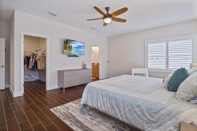 bedroom with ceiling fan, a walk in closet, a closet, and ensuite bath