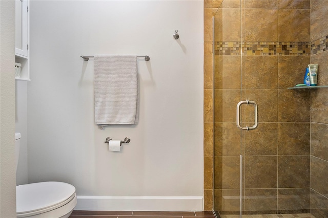 bathroom with a shower with shower door and toilet