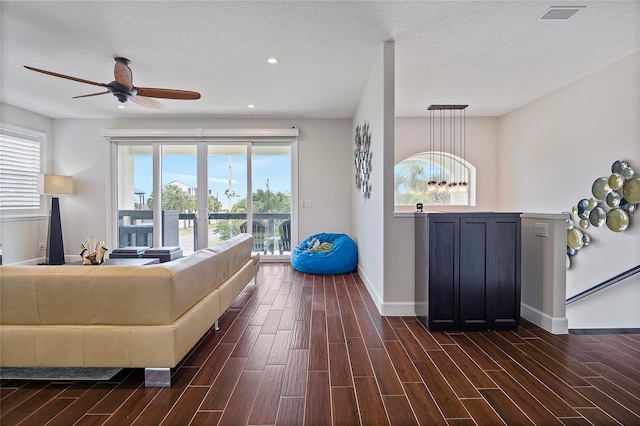 living room with ceiling fan and a textured ceiling