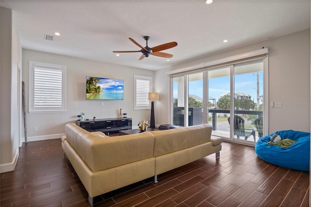 living room with ceiling fan and a textured ceiling