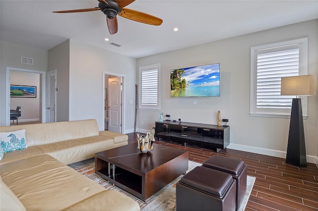 living room featuring ceiling fan and dark hardwood / wood-style flooring