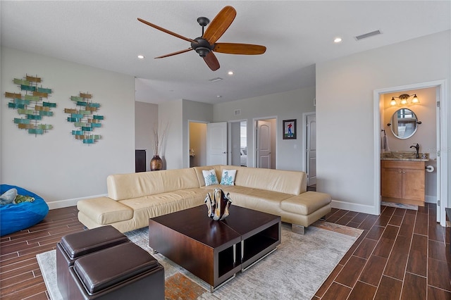 living room featuring ceiling fan and sink