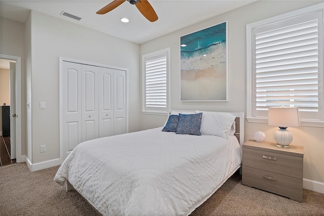 carpeted bedroom with ceiling fan and a closet