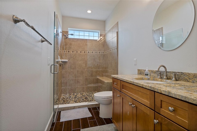 bathroom with toilet, vanity, and walk in shower