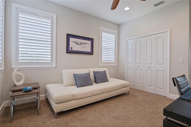 carpeted living room with ceiling fan