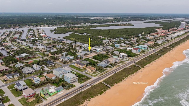 birds eye view of property with a water view and a beach view