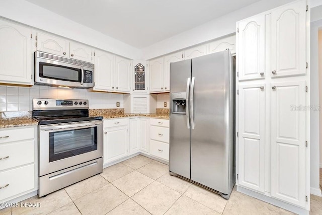 kitchen featuring light stone counters, light tile patterned floors, white cabinets, and stainless steel appliances