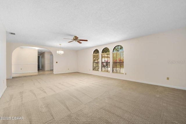 spare room featuring ceiling fan, light colored carpet, and a textured ceiling