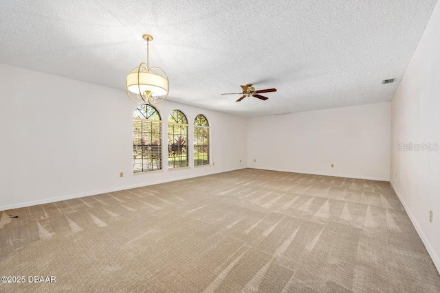 carpeted empty room featuring a textured ceiling and ceiling fan