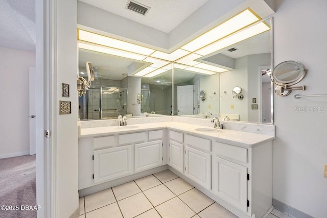 bathroom with tile patterned floors, a shower with shower door, and vanity