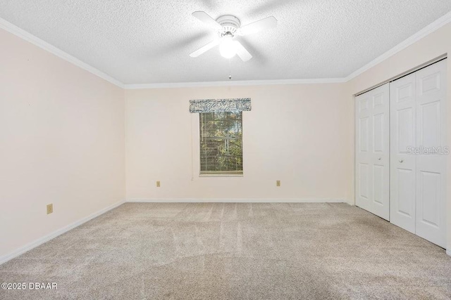 unfurnished bedroom featuring ceiling fan, light colored carpet, a textured ceiling, and a closet