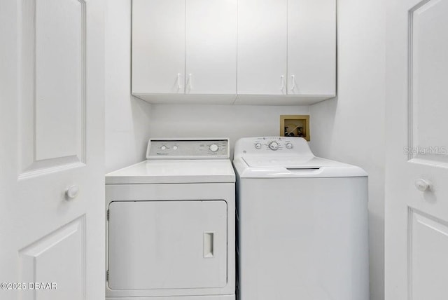 laundry area with washing machine and dryer and cabinets