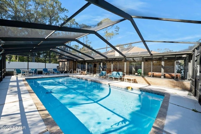 view of pool with glass enclosure and a patio area