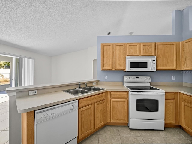 kitchen with light tile patterned flooring, sink, kitchen peninsula, and white appliances