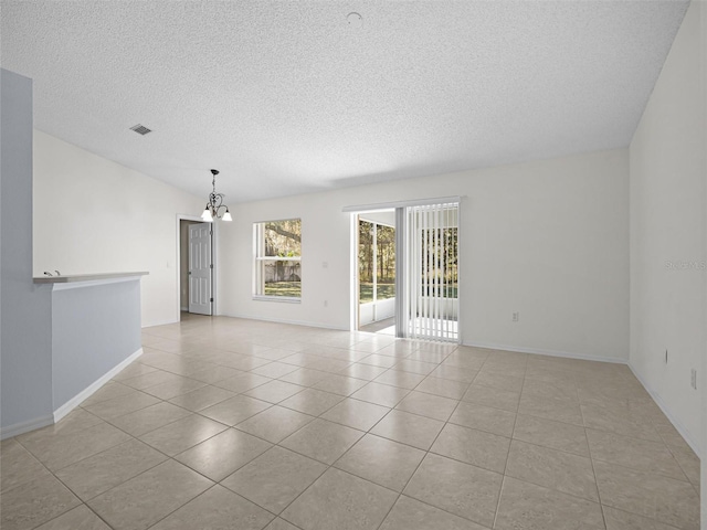 tiled empty room with a chandelier