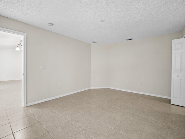 tiled spare room with a textured ceiling