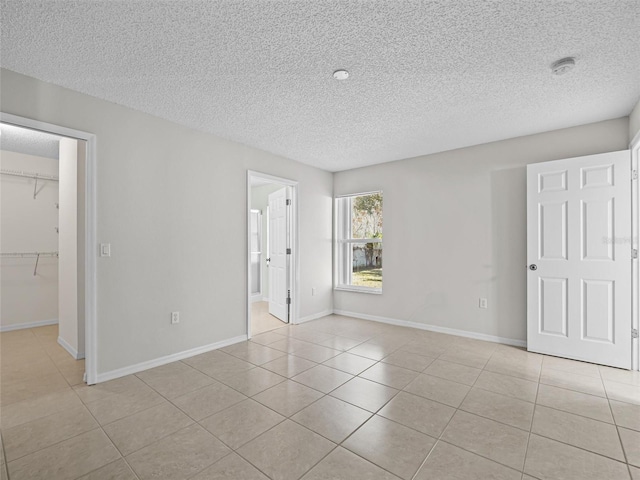 tiled empty room with a textured ceiling