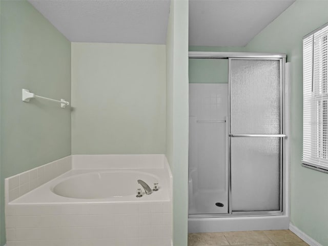 bathroom featuring plus walk in shower, a textured ceiling, and tile patterned floors