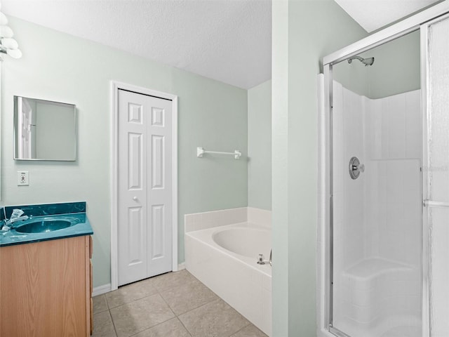 bathroom with a textured ceiling, vanity, independent shower and bath, and tile patterned flooring