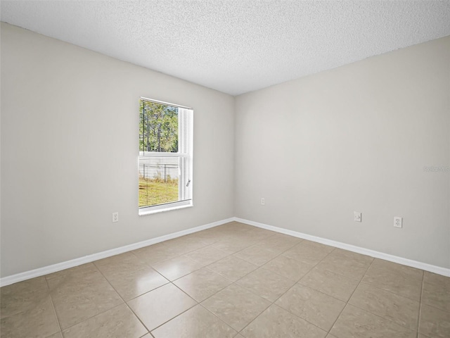 tiled spare room with a textured ceiling