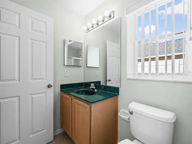 bathroom featuring toilet, tile patterned flooring, a healthy amount of sunlight, and vanity