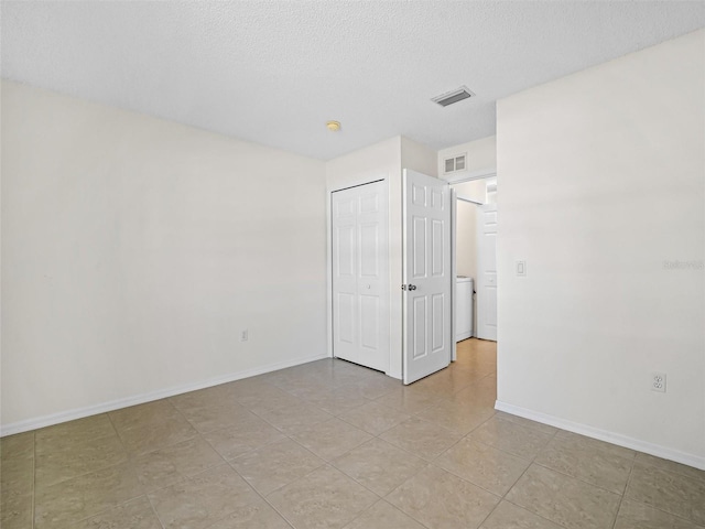 tiled spare room featuring a textured ceiling