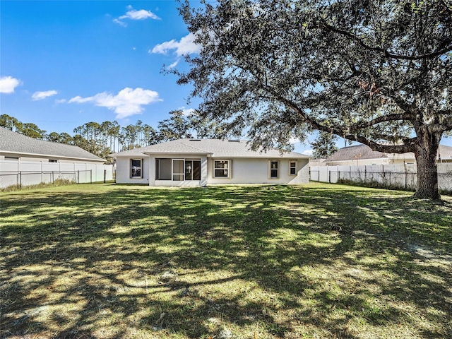 rear view of property featuring a yard