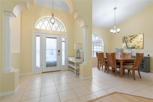 tiled foyer featuring ornate columns, a chandelier, and a healthy amount of sunlight