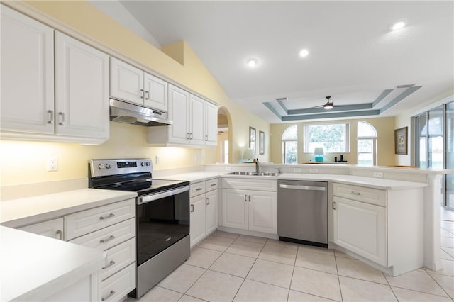 kitchen featuring white cabinets, stainless steel appliances, sink, kitchen peninsula, and a raised ceiling