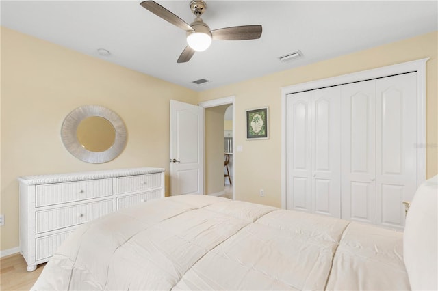 bedroom featuring light wood-type flooring, ceiling fan, and a closet