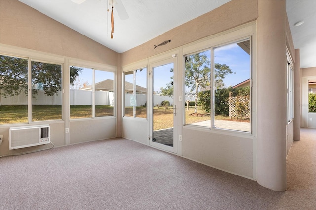 unfurnished sunroom with vaulted ceiling, ceiling fan, a wealth of natural light, and a wall mounted air conditioner