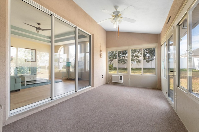 unfurnished sunroom with ceiling fan, lofted ceiling, plenty of natural light, and an AC wall unit