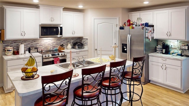 kitchen featuring white cabinetry, sink, decorative backsplash, and stainless steel appliances