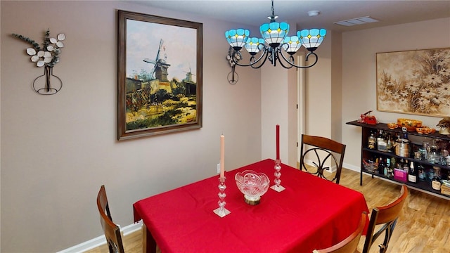 dining space featuring hardwood / wood-style floors and a notable chandelier