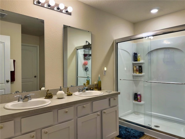 bathroom featuring vanity and a shower with shower door