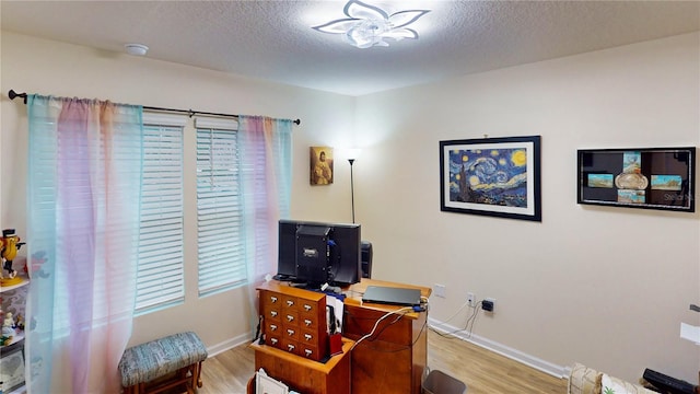 office area with a textured ceiling and light wood-type flooring