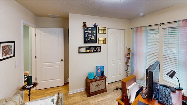 office featuring light hardwood / wood-style floors and a textured ceiling