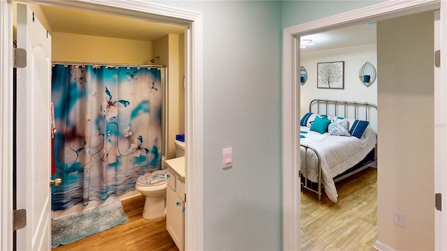 bathroom with hardwood / wood-style flooring, vanity, and toilet