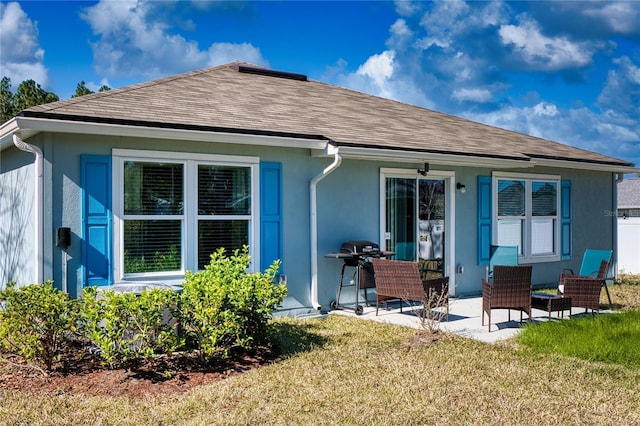 rear view of property featuring a patio and a lawn