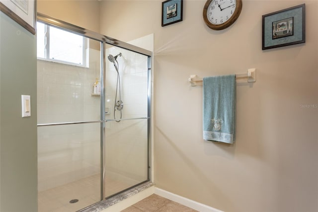 bathroom featuring a shower with shower door and tile patterned floors