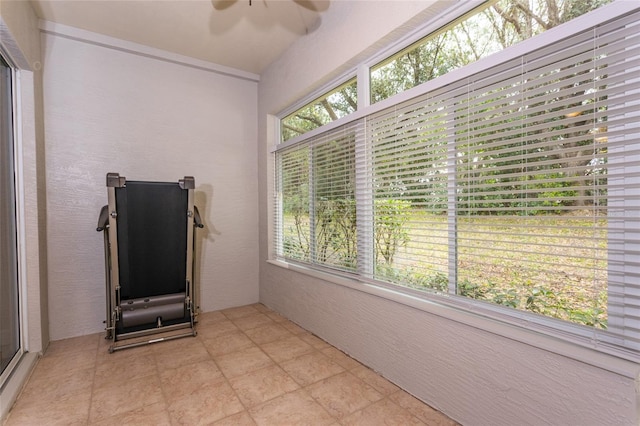 exercise room featuring ceiling fan and light tile patterned floors