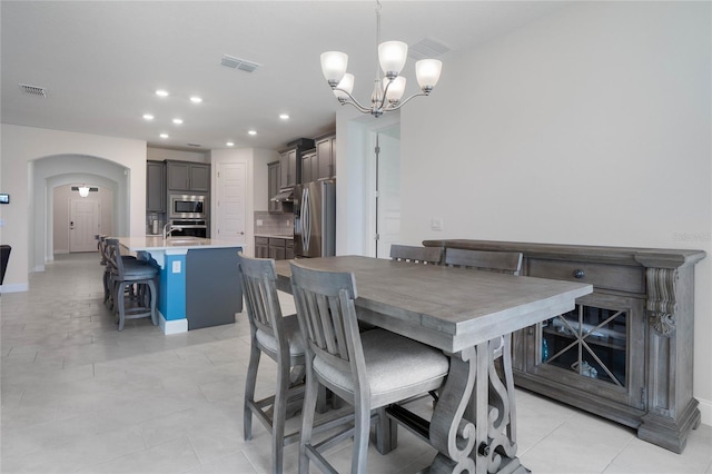 tiled dining area featuring sink and a chandelier