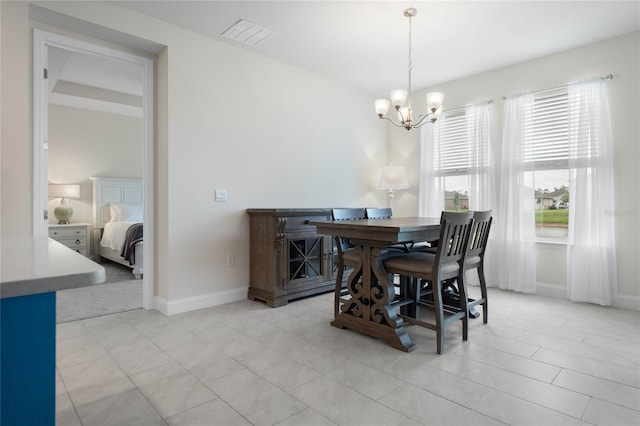 dining area featuring plenty of natural light, light tile patterned floors, and a chandelier